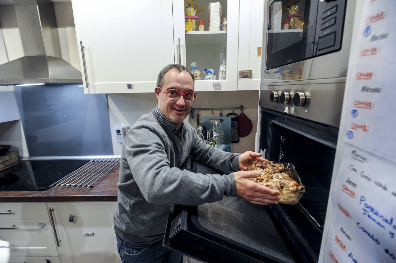 Ellos cocinan bajo la atenta mirada y asesoramiento de su educadora, Maitane. Siempre, comida equilibrada. Markel saca del horno conejo con patatas panadera.