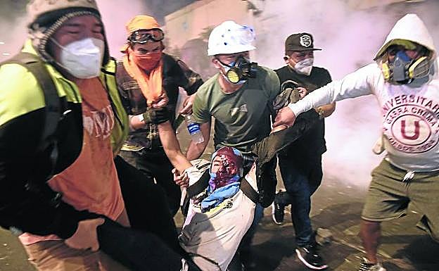 Un grupo de manifestantes traslada a uno de los heridos durante los choques con la Policía. 