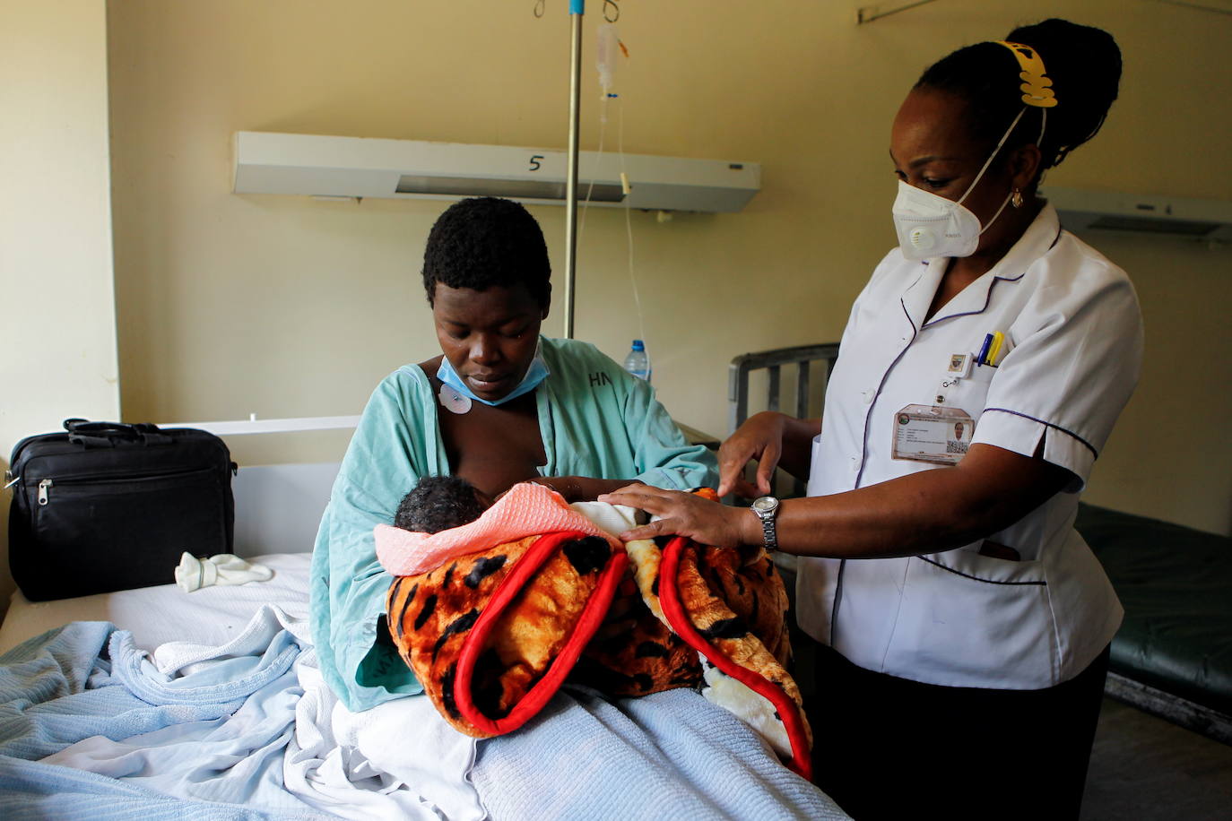 Una enfermera le muestra a la estudiante de secundaria Jackline Bosibori, de 17 años, cómo amamantar a su bebé de un día en el Hospital Nacional Kenyatta en Nairobi, Kenia.