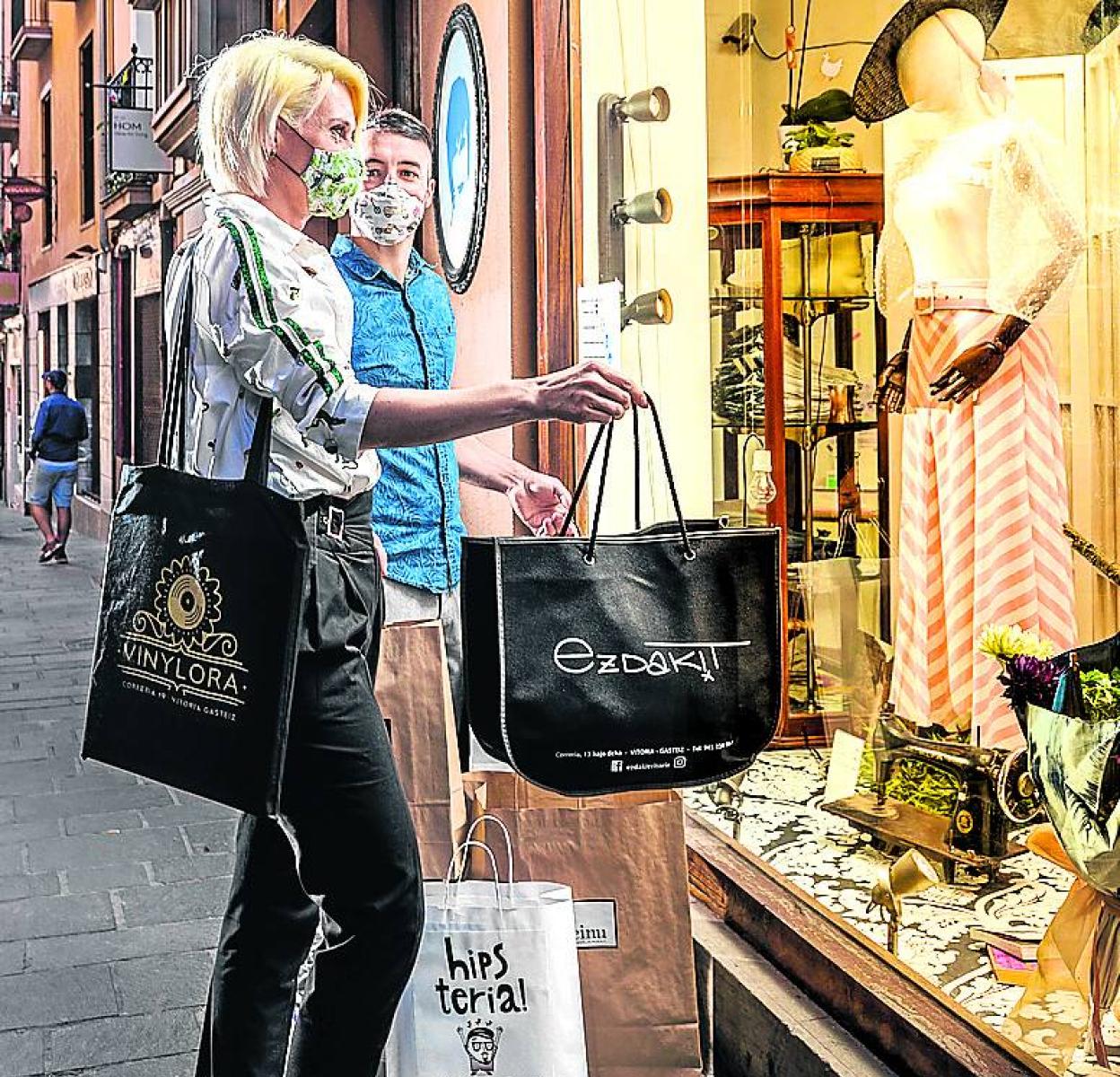 Dos personas ante un escaparate de una tienda en Vitoria. 