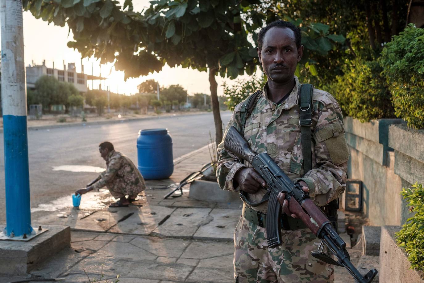 Un miembro de las Fuerzas Especiales de Amhara sostiene su arma mientras otro se lava la cara en Humera, Etiopía.