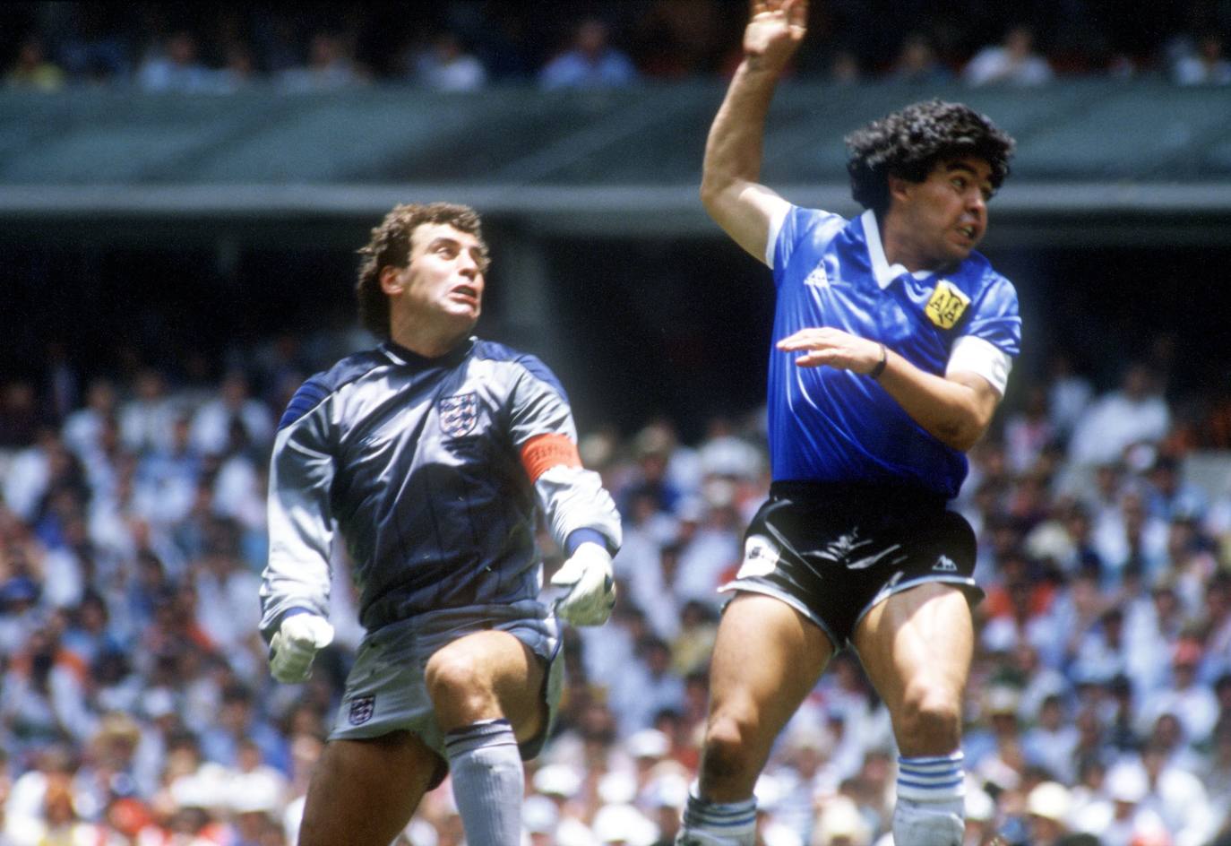 Diego Armando Maradona, en el momento que supera, con la mano ("la mano de Dios"), la salida del portero inglés en México 1986.
