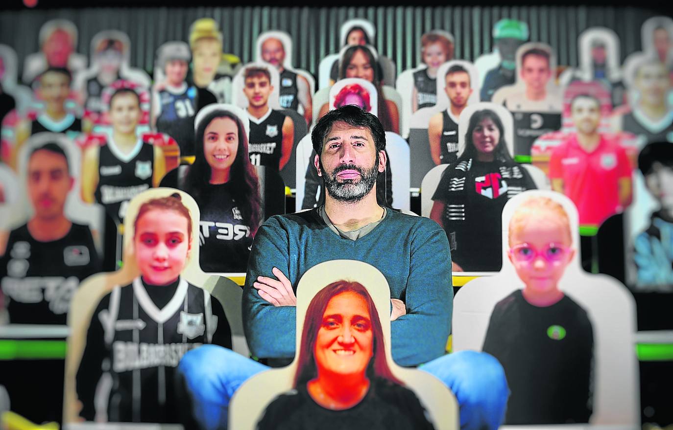 Álex Mumbrú posa ayer en las gradas del Bilbao Arena junto a las fotografías de aficionados que tratan así de recordar a los hombres de negro que no están solos.