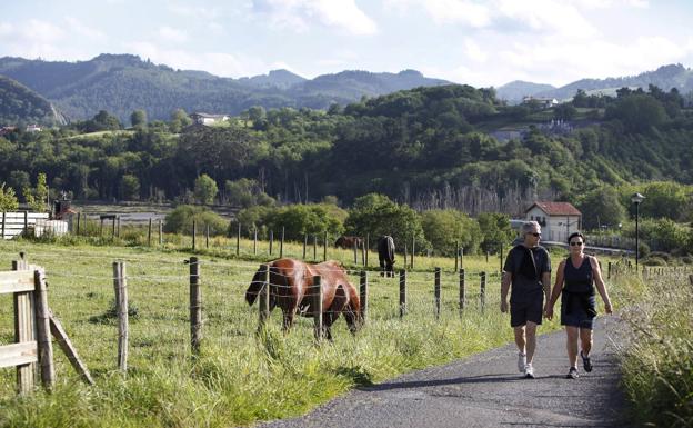 Una pareja camina por un sendero de Sukarrieta. 