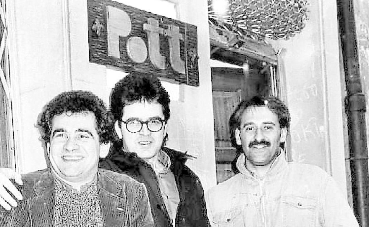 Bernardo Atxaga, Ruper Ordorika y Joxemari Iturralde posan delante de la librería que un amigo abrió con el nombre de la banda Pott. 