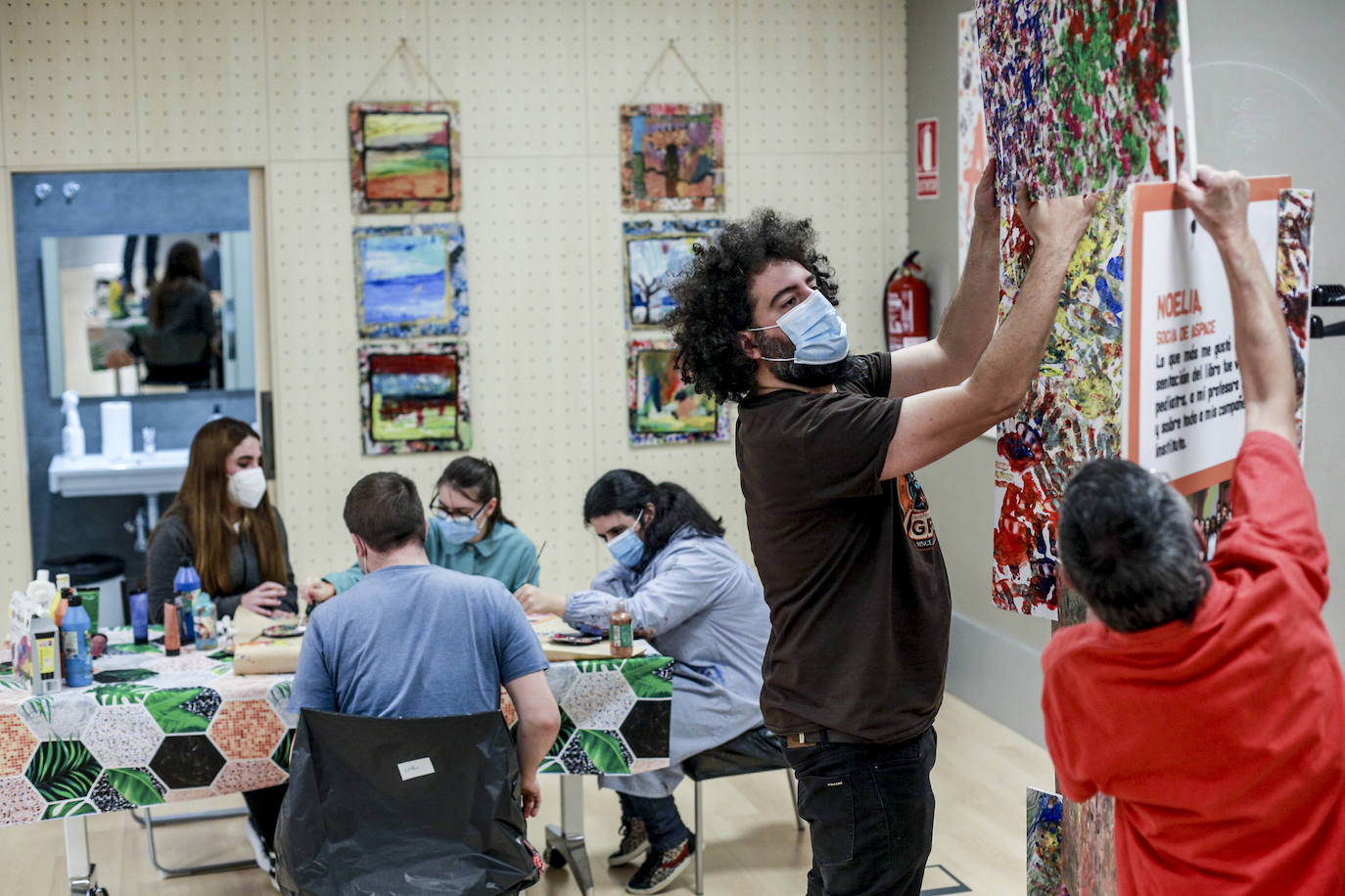 Usuarios y voluntarios participan en el taller de pintura de la asociación de parálisis cerebral Aspace, una de las numerosas actividades de las que disfrutan sus más de 130 miembros.