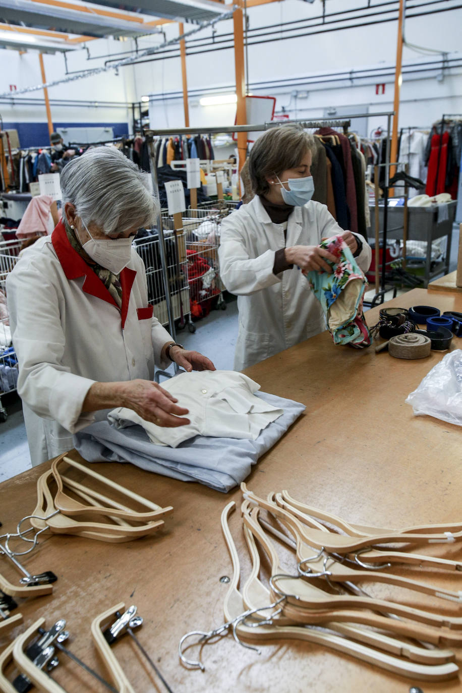 Voluntarias de Cáritas arreglan, lavan y preparan prendas recogidas en los contenedores que Koopera tiene repartidos por Vitoria para dejarlas listas para sus próximos dueños.