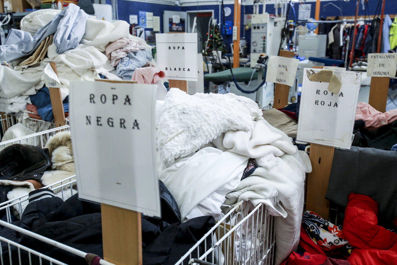 Voluntarios de Cáritas arreglan, lavan y preparan prendas recogidas en los contenedores que Koopera tiene repartidos por Vitoria para dejarlas listas para sus próximos dueños. Este programa también ayuda a la inserción laboral de personas que lo necesitan.