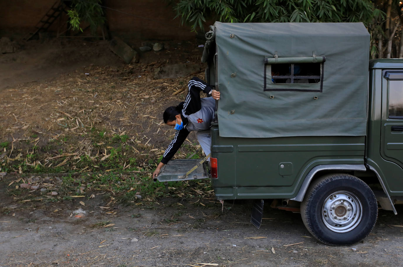 Una soldado raso de 25 años, cierra la puerta de un vehículo mientras ella y sus colegas (sin ser vistos) abandonan el área de cuarentena en las instalaciones del cuartel del ejército.