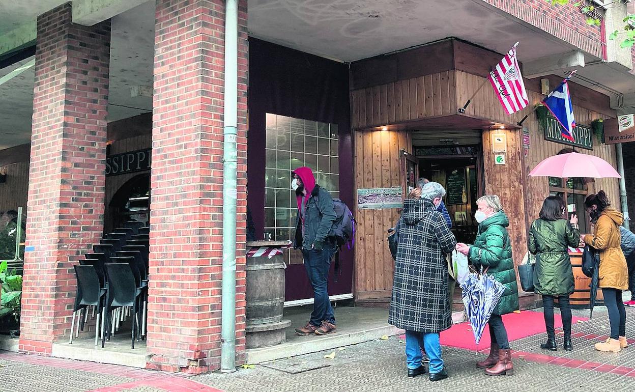 Varios clientes aguardan en el exterior del bar Mississippi para adquirir unos cafés.