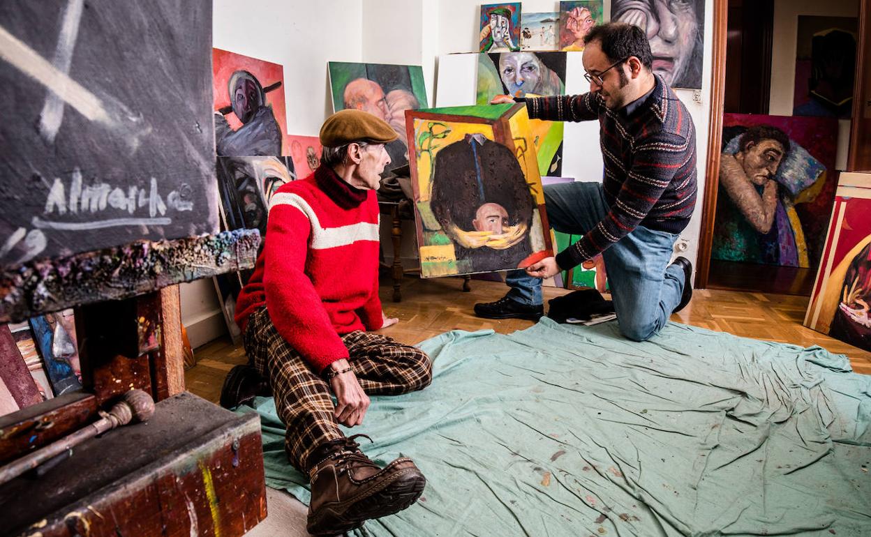 El director de 'Buruak', Aitor López de Aberásturi, sujera un lienzo ante la mirada de su autor, el pintor Gustavo Adolfo Almarcha.