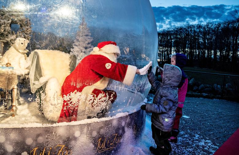 Dinamarca. Una persona vestida como Papá Noel se reúne con niños mientras está sentada en una "burbuja de Papá Noel" mientras abre la temporada navideña en el zoológico de Aalborg, en medio del brote de coronavirus, en Aalborg.