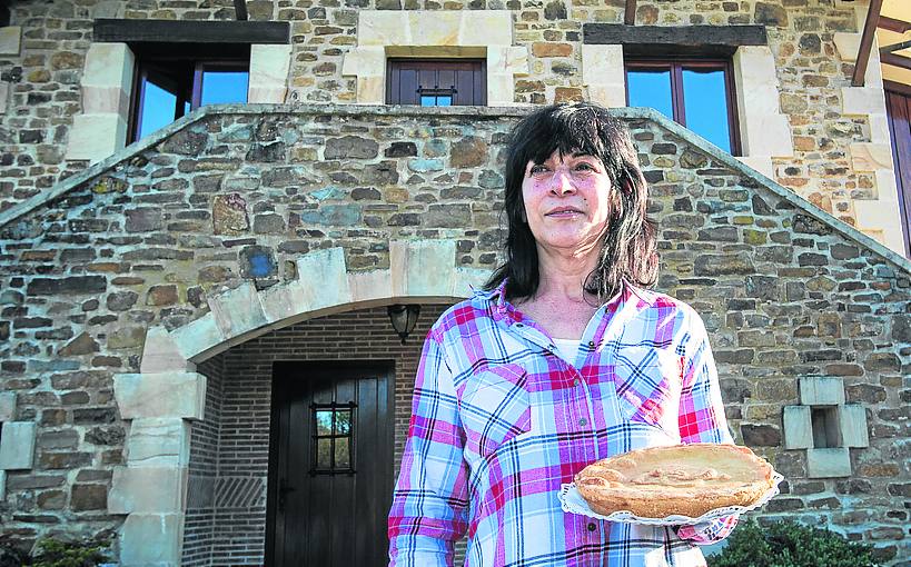 Ana Añibarro muestra uno de sus pasteles junto a su caserío de Orozko.