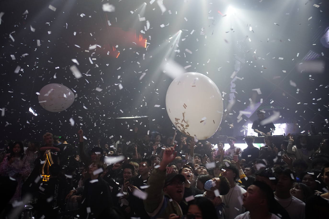 Cientos de personas bailan en una discoteca.