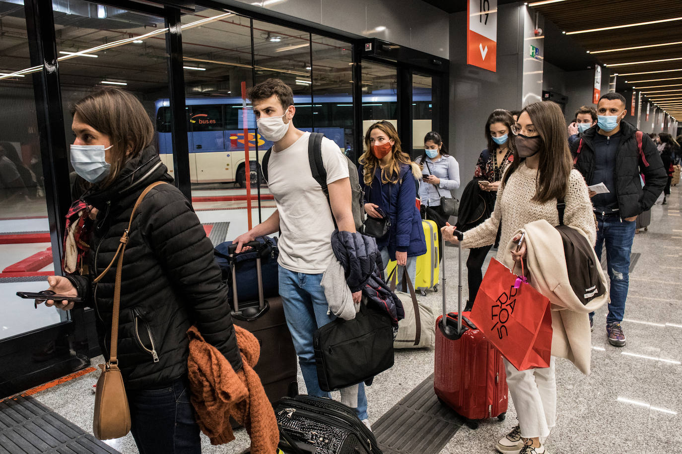 Colas de pasajeros esperando para subir a los autobuses.