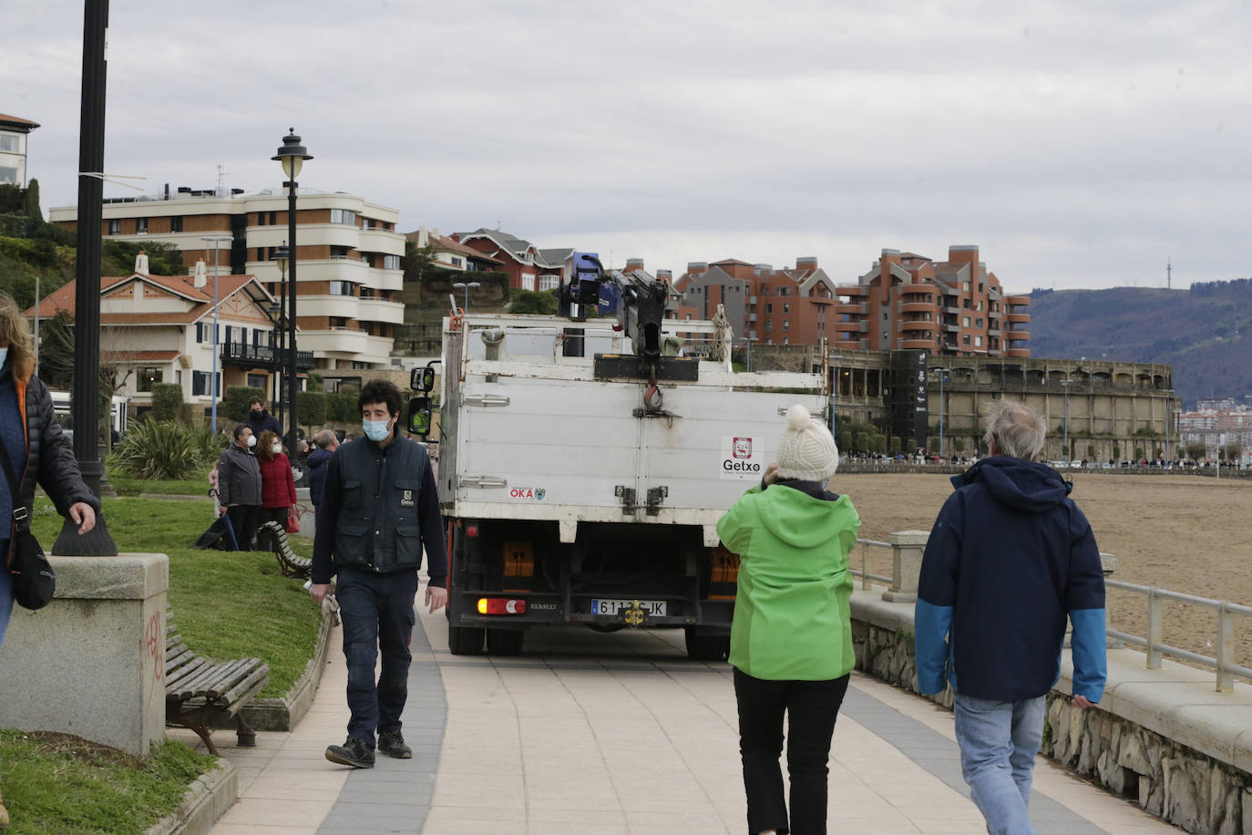 Operarios repartiendo sacos de tierra para preparar el temporal de la próxima madrugada.