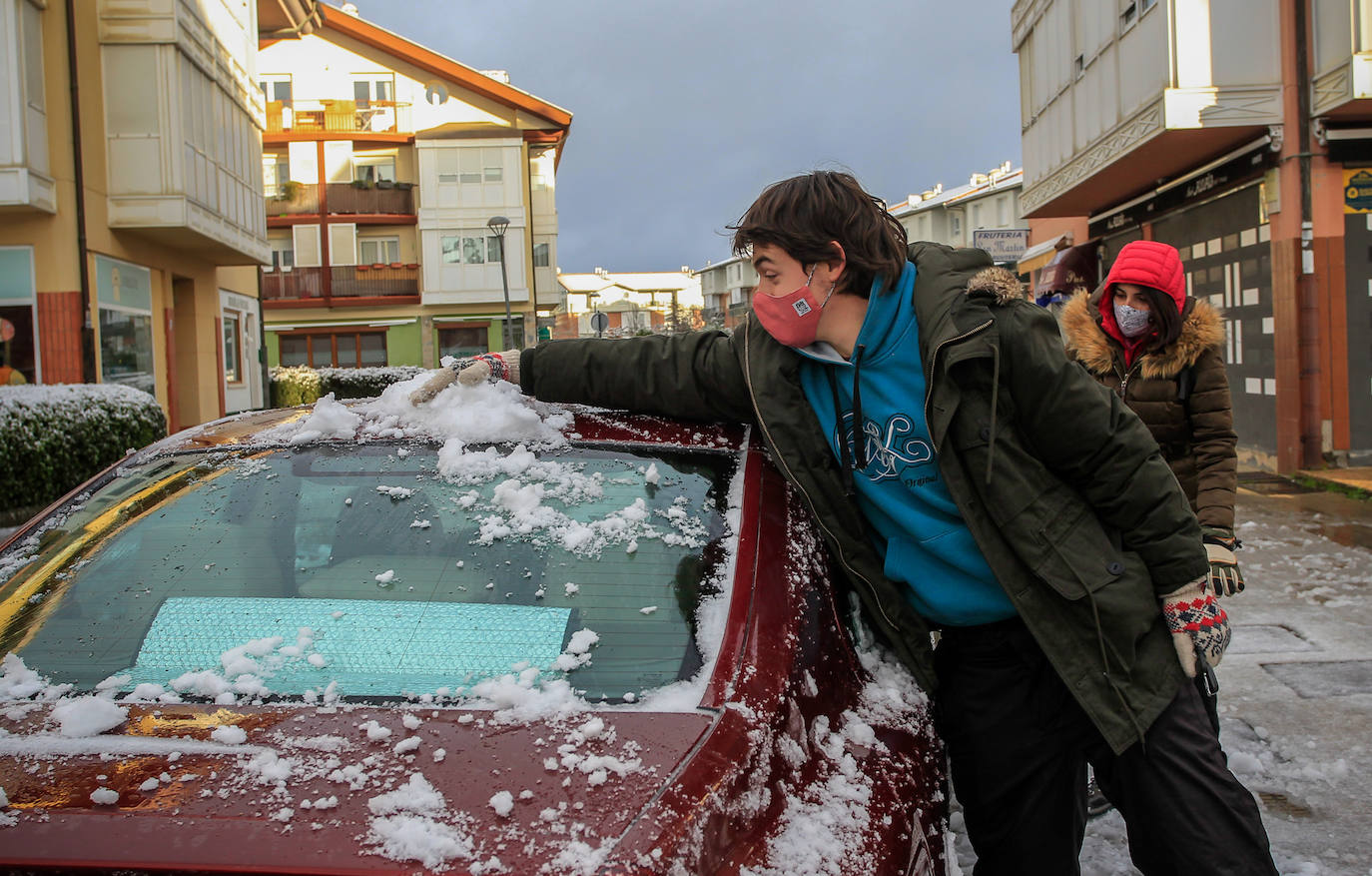 Unos jóvenes retiran la nieve del coche, en Murgia.