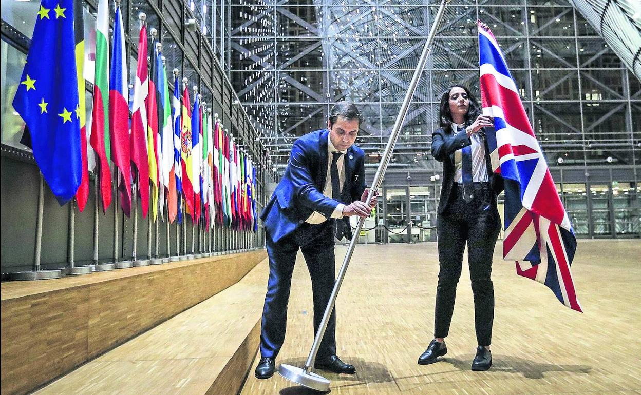 Funcionarios comunitarios retiran la bandera de Reino Unido del edificio del Consejo Europeo en Bruselas el 31 de enero de 2020, día del Brexit. 