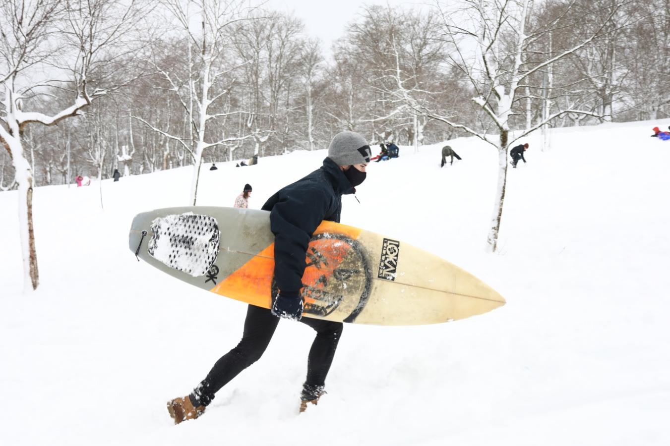Un joven porta una tabla de surf en los alrededores de Urkiola.