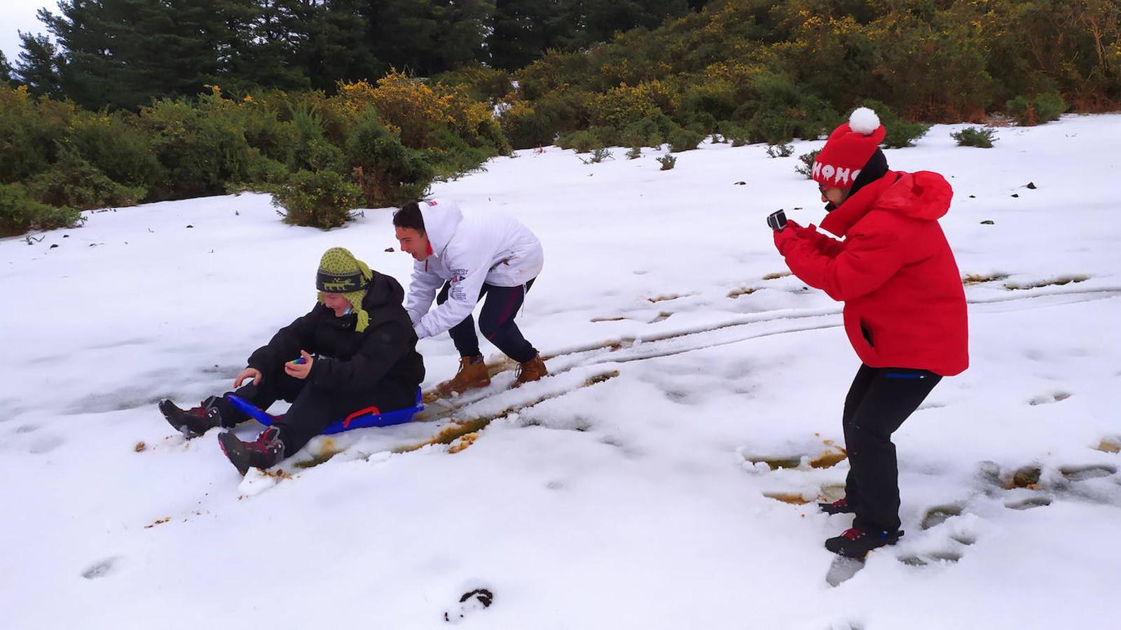 Unos jóvenes juegan con la nieve en las cercanías de La Arboleda. 