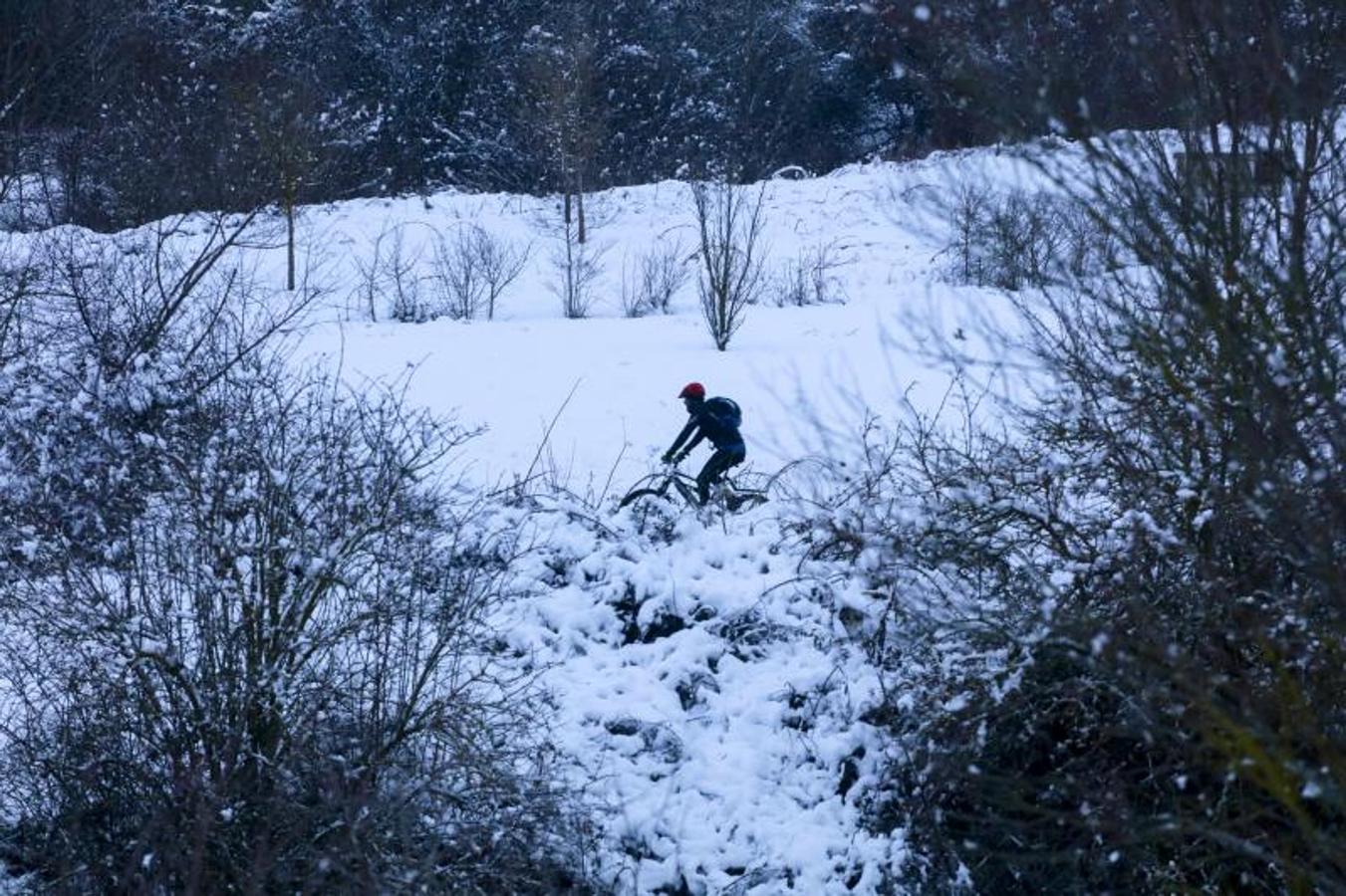 Un ciclista pedalea por los alrededores nevados de Vitoria. 