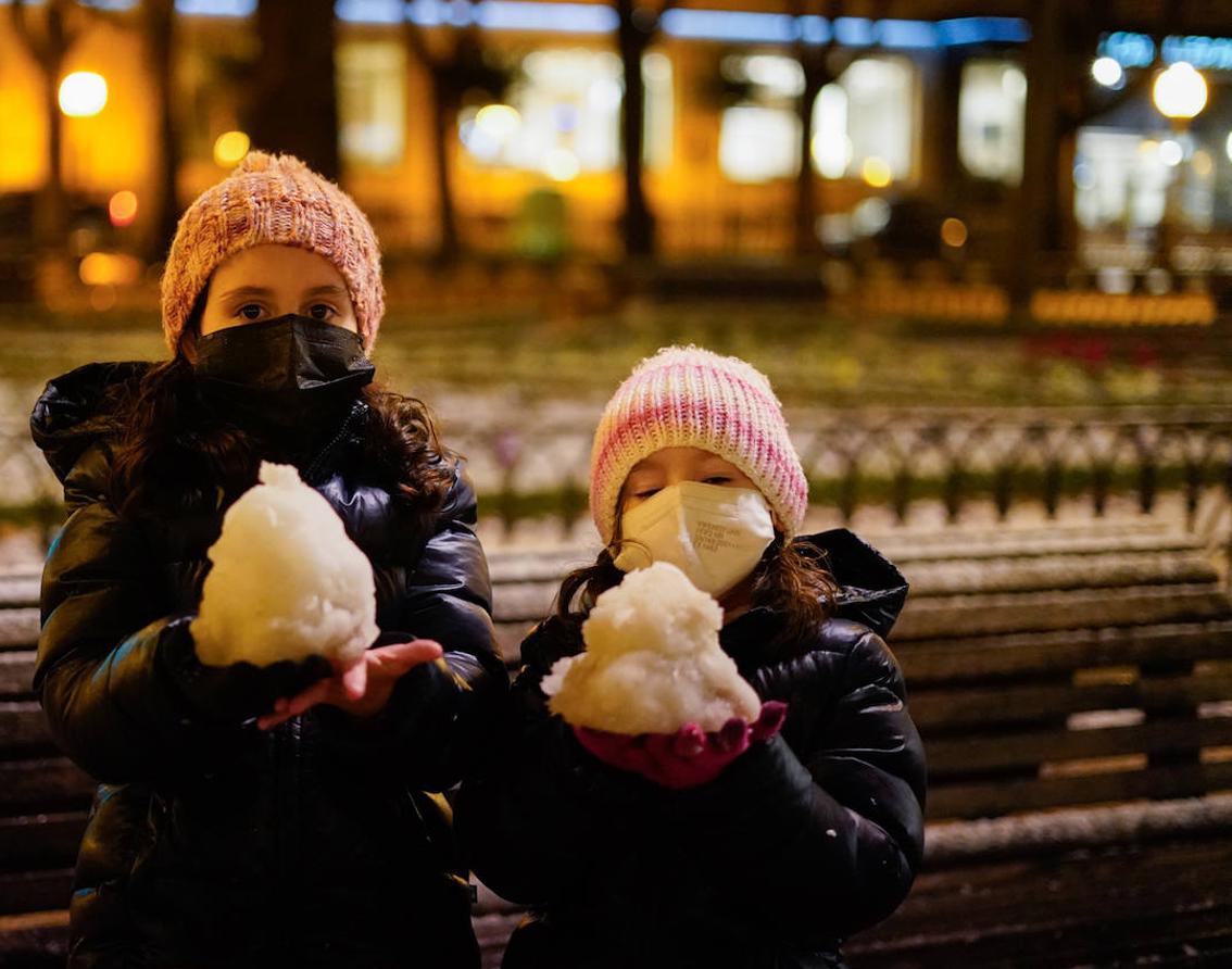 Dos niñas juegan en Vitoria con la nieve.