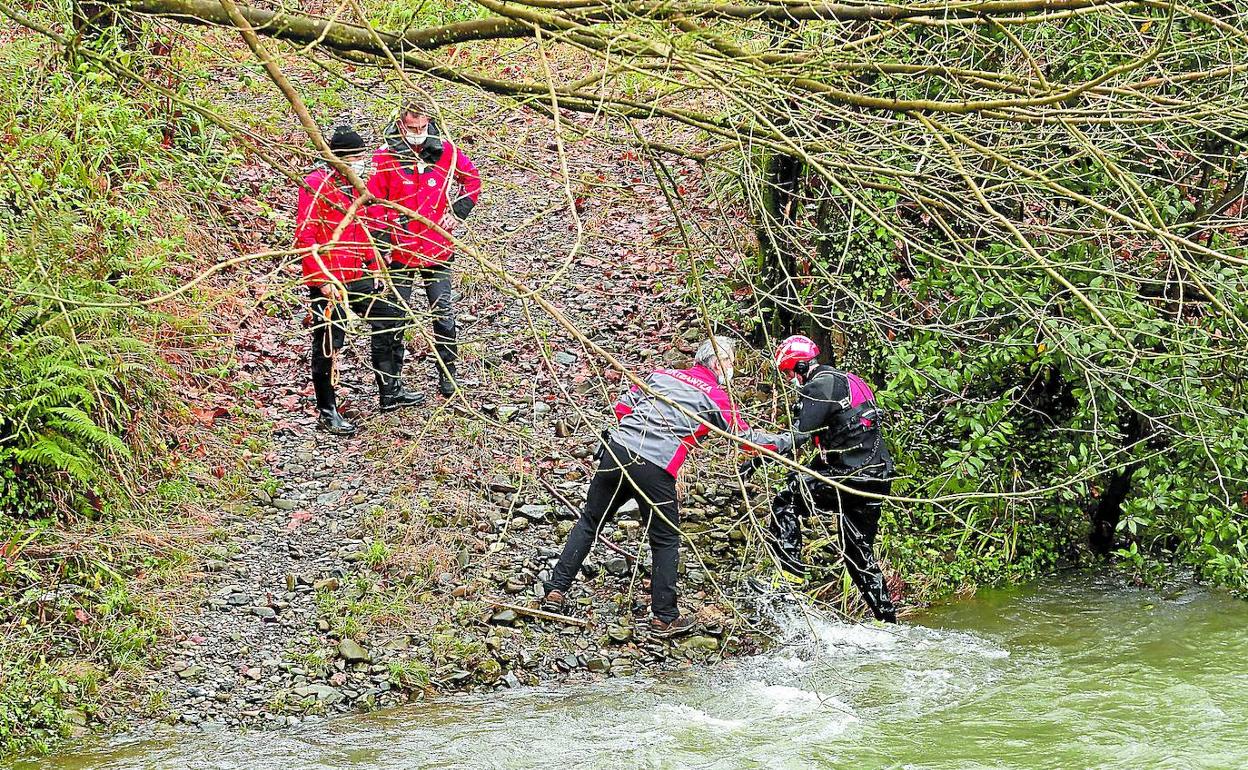 Agentes de la Ertzaintza encargados de la investigación recogen pruebas en la zona donde apareció el cadáver. 