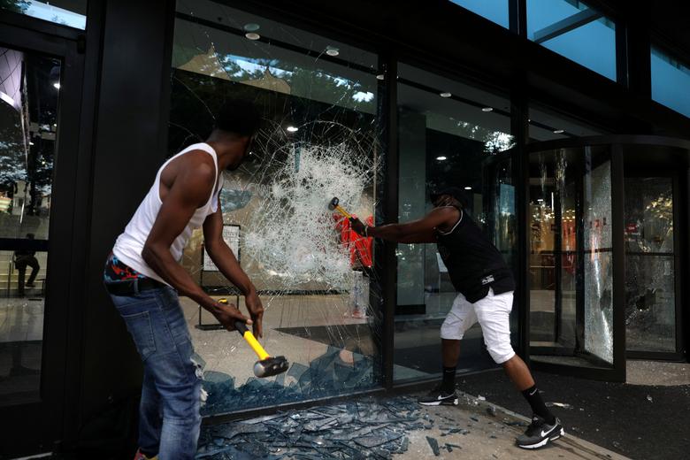 Los manifestantes rompen una ventana en el CNN Center.