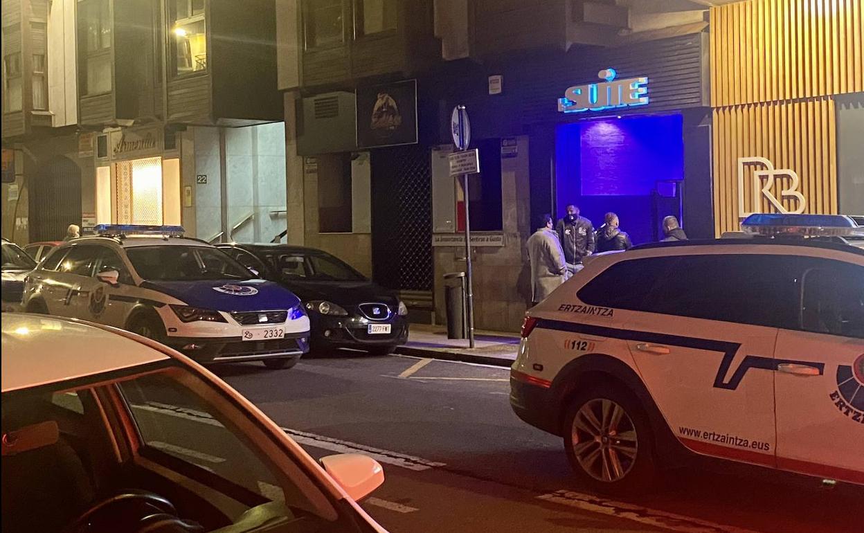 Uno de los coches policiales en el exterior del local.