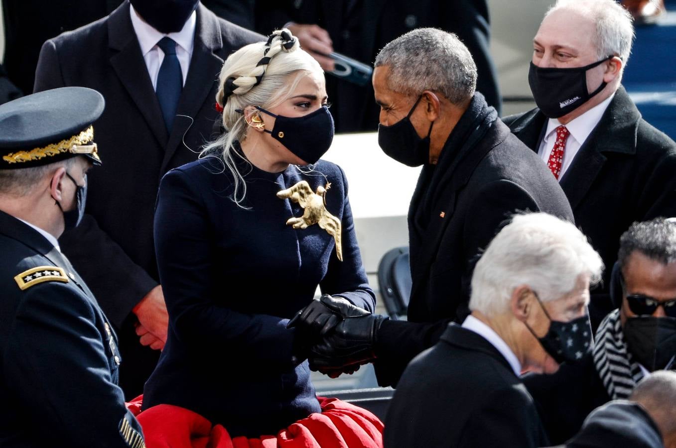 Lady Gaga y el ex presidente estadounidense Barack Obama se saludan durante la toma de posesión de Joe Biden.