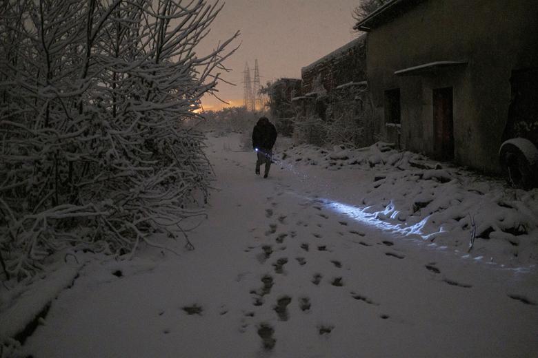 Un migrante camina frente a una fábrica abandonada donde se alijan varios de ellos.