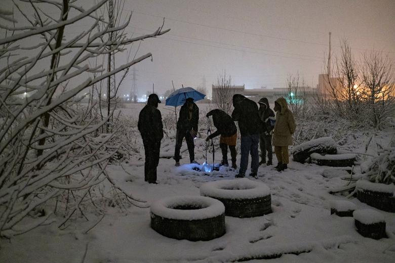 Los migrantes se reúnen para recoger agua 