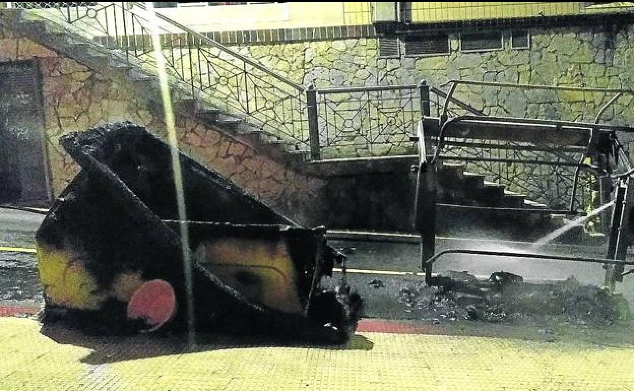 Un bombero sofoca las llamas de uno de los contenedores quemados en octubre. 