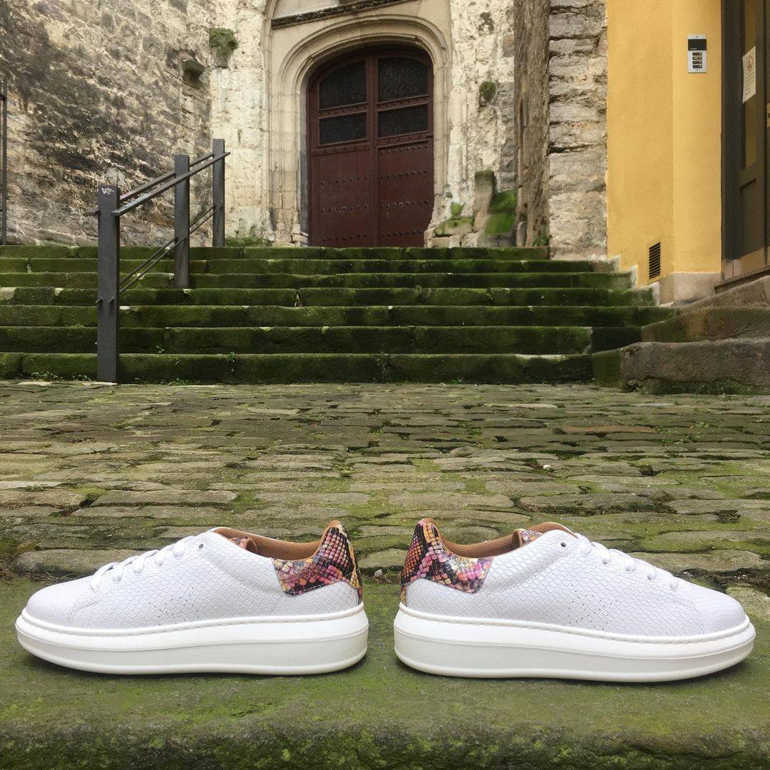 Zapatillas blancas con estampado de serpiente muticolor en la parte trasera. Te están esperando en Boga Zapatería y tienen un precio de 89 euros.