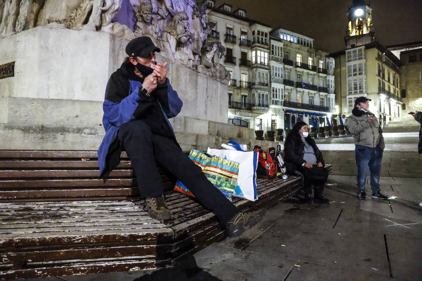 Armando Fernández se enciende un cigarro en la plaza de la Virgen Blanca antes de recoger sus cosas e irse a dormir al albergue municipal.