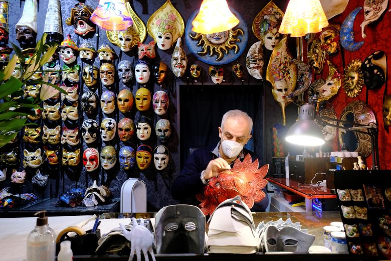 Un artesano de máscaras trabaja dentro de su tienda durante lo que habría sido el carnaval anual de Venecia en Venecia.