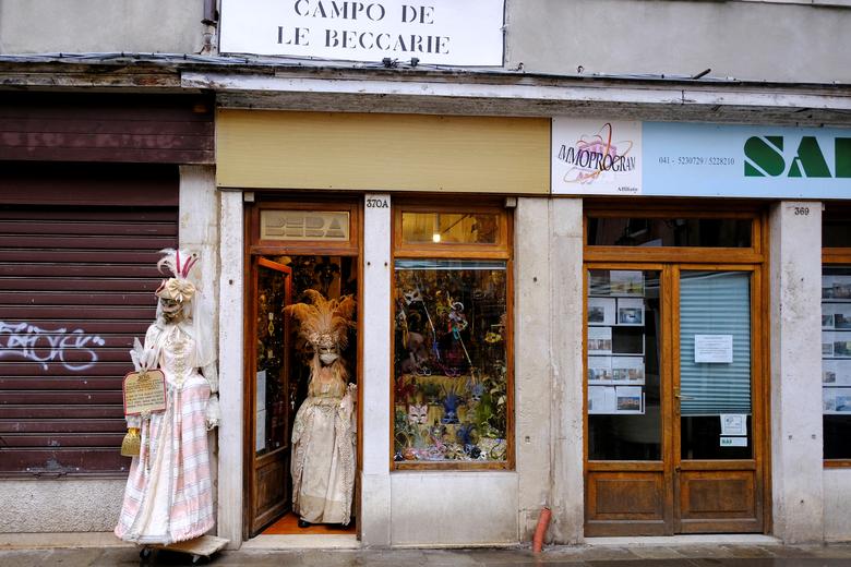 El dueño de una tienda de artesanos de máscaras con un disfraz sale para celebrar el carnaval anual de Venecia, que ha sido cancelado este año debido al coronavirus, en Venecia.