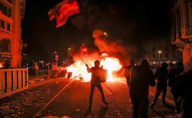 Varios manifestantes incendian una barricadad en Barcelona. .