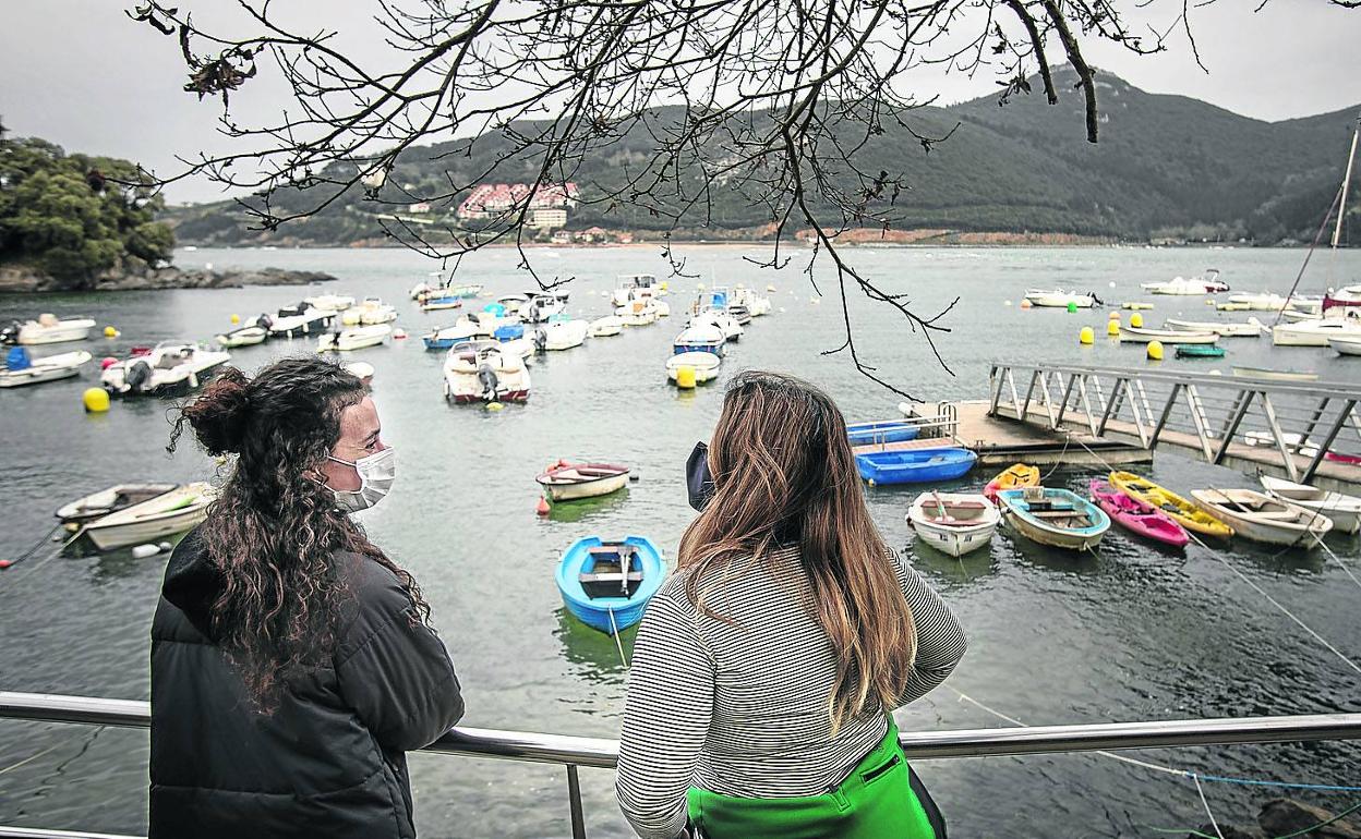 Dos jóvenes miran hacia la marisma de Sukarrieta, que lleva desde el 15 de enero sin sumar nuevos contagios. 