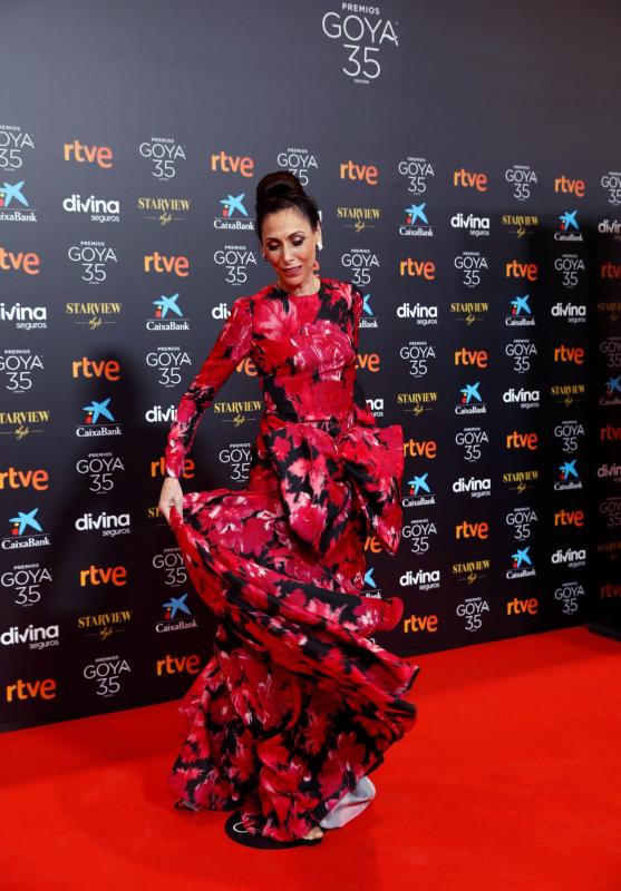 Malagueña, chica Almodóvar y con dos Goya en su poder, la actriz se ha desmarcado del resto de looks de alfombra roja gracias a un primaveral estampado con flores XL en tonos rojos de Pertegaz. Se trata de un vestido de cuello a caja, manga larga, cuerpo ceñido y falda con volumen.Una silueta princesa con detalle de lazo XL, que integra dos bolsillos laterales, algo muy recurrente en la historia de las alfombras rojas y que hemos visto en multitud de ocasiones a grandes actrices nacionales e internacionales. Lo ha combinado con joyas de Roberto Coin.