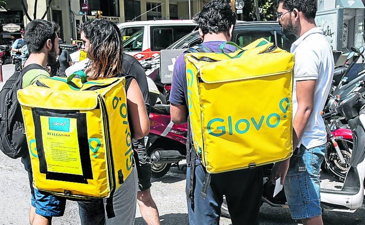 Varios repartidores aguardan a que les comuniquen sus encargos. 