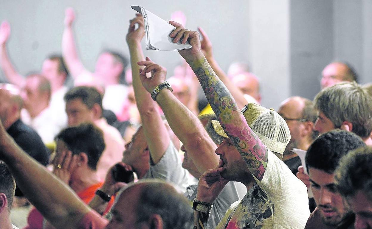 Socios del Barakaldo votan a mano alzada durante una asamblea del club fabril.