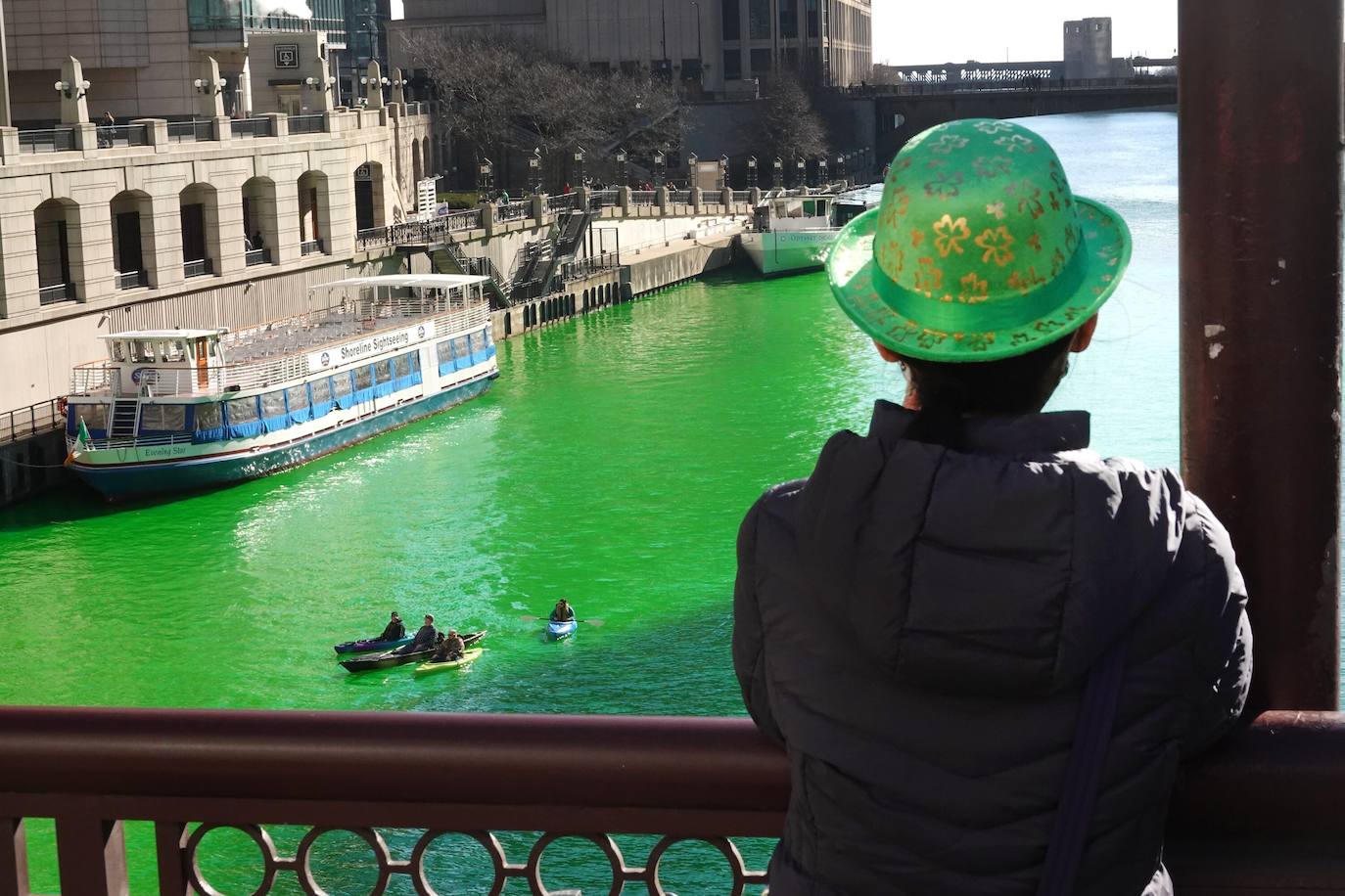 Un hombre ve el río Chicago después de haber sido teñido de verde en celebración del Día de San Patricio en Chicago, Illinois.