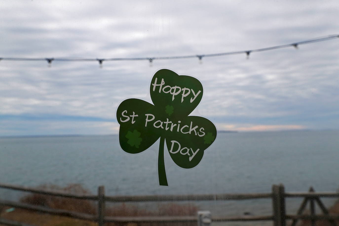 Un trébol que dice "Feliz día de San Patricio" se ve en la ventana de un bar en el extremo este de Long Island en Montauk, Nueva York.