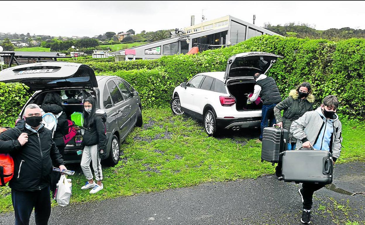 Dos familias sacan su equipaje del coche para instalarse este viernes en el camping de Sopela.