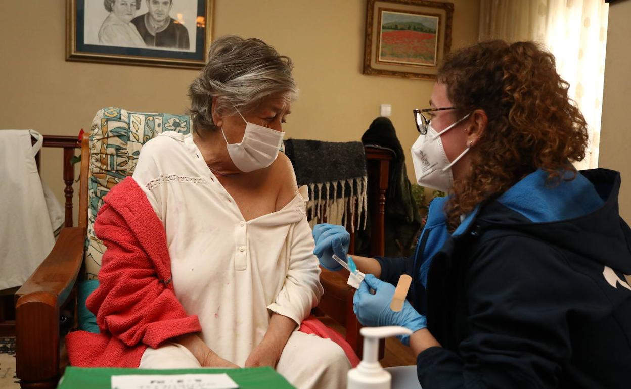 Una enfermera de Osakidetza vacuna a una mujer mayor de 80 años en su domicilio. 