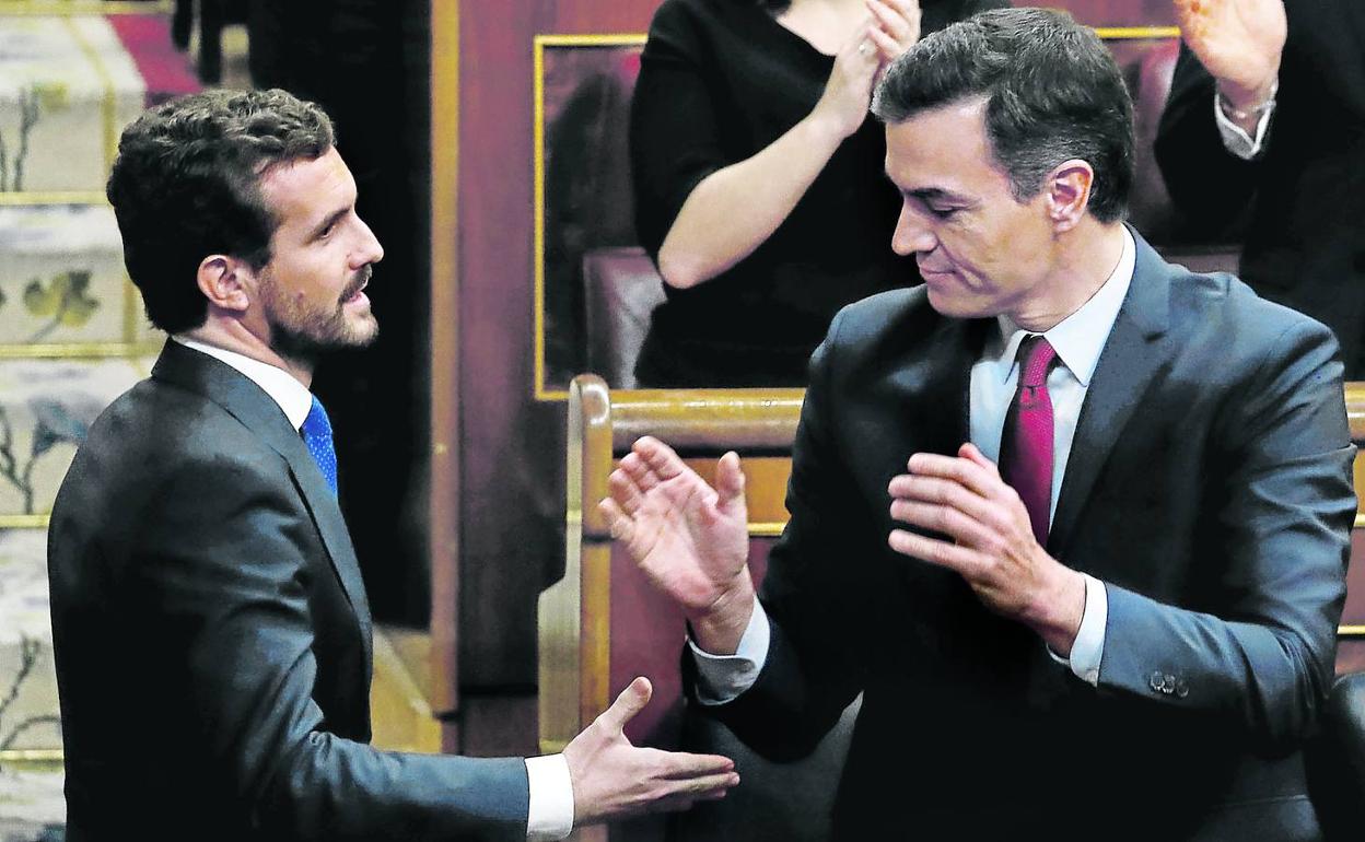 El líder del PP, Pablo Casado, se acerca a felicitar a Pedro Sánchez tras su investidura como presidente del Gobierno en enero del año pasado. 