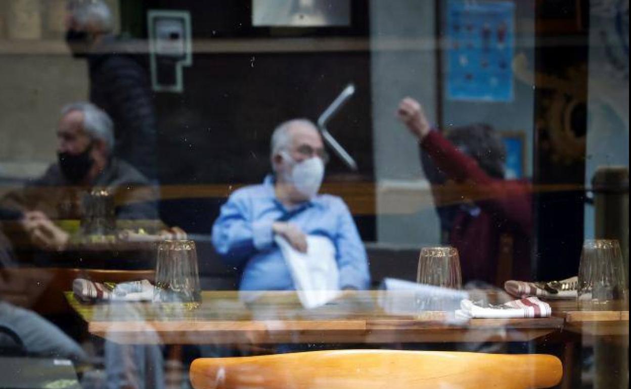 Varios hombres conversan junto a un restaurante. 