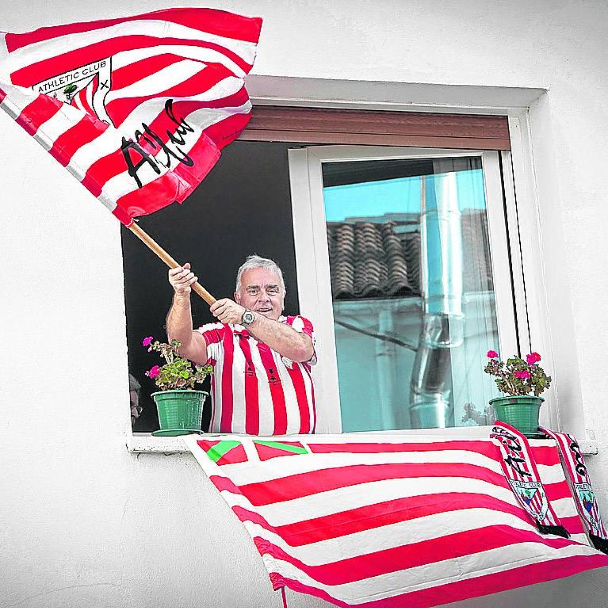 Un aficionado ondea desde su ventaja la bandera del Athleticx. 