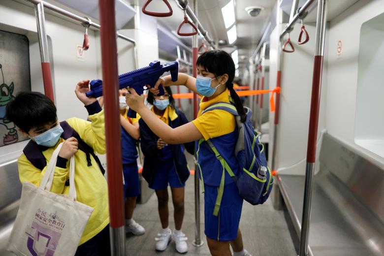 Un niño juega con una metralleta simulada en una estación modelo Mass Transit Railway (MTR) durante la jornada de puertas abiertas para conmemorar el Día Nacional de Educación en Seguridad, en la Escuela de Policía de Hong Kong, en Hong Kong, China.